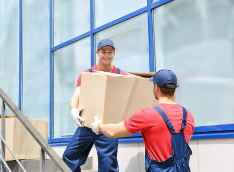Removal staff carrying office furniture through a commercial property